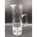 A stunning and substantial hand-blown tall glass jug with a thick heavy base and large handle