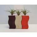 Three colourful ceramic vases with faux grass