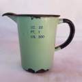 A lovely antique green enamel measuring jug in ounce, pint and grams