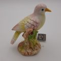Pink and Yellow Bird Sitting on Branch Figurine