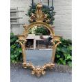 Ornately carved and gilded mirror