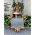 Ornately carved and gilded mirror