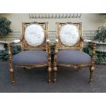 An Exceptional Pair of French Style Carved and Gilded Armchairs Upholstered in a Custom-Made Line...