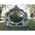 A French Ornate carved painted mirror with a bevelled centre section