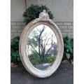 An Oval Ornate Bevelled Mirror