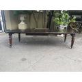 A three meter Victorian mahogany extending dining table on carved legs and castors, with four lea...
