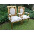 A 20TH Century Pair Of Ornately Carved And Hand Gilded French Style Armchairs Upholstered in a Cu...