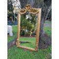 A French Style Ornately Carved and Gilded Bevelled Mirror