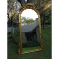 A French Style Ornately Carved Arched and Gilded Bevelled Mirror