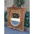 A 20th Century French Style Ornately Carved and Gilded Bevelled Mirror