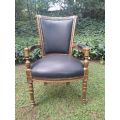 A 20th Century French Louis XVI Styled Ornately Carved And Gilded Arm Chair upholstered in black ...