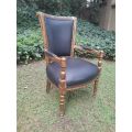 A 20th Century French Louis XVI Styled Ornately Carved And Gilded Arm Chair upholstered in black ...