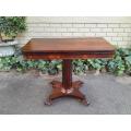 A Victorian rosewood swivel and tilt CARD TABLE, on spreading hexagonal column to the concave pla...