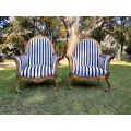 A 20th Century Pair of French Style Louis XVI Style Ornately Carved and Gilded Armchairs