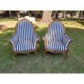 A 20th Century Pair of French Style Louis XVI Style Ornately Carved and Gilded Armchairs