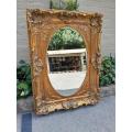 A 20th Century French Style Ornately Carved Bevelled and Gilt Wood Mirror