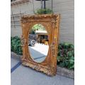 A 20th Century French Style Ornately Carved Bevelled and Gilt Wood Mirror