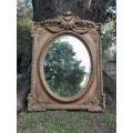 A French Rococo Style Ornately Carved and Gilded Bevelled Mirror