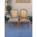 A Pair of French Style Ornately Carved and Gilded Rattan High Back Armchairs