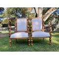 A Pair of French Style Ornately Carved Giltwood Arm Chairs