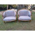 A Pair of French Ornately Carved and Gilded Bergere Chairs