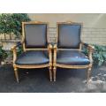 A Pair of French Style Carved and Gilded Armchairs Upholstered in Leather