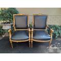 A Pair of French Style Carved and Gilded Armchairs Upholstered in Leather