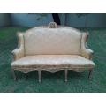An Early 20th Century French Style Ornately Carved and Gilded Wingback Settee