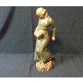 A WOOD CARVING OF WOMAN HOLDING A BABY