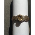 A siver ring with yellow stones cushion cut stone