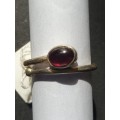 A siver ring with red stones ovel cut stone