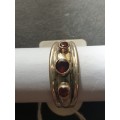 A sliver ring with 3 red stones rowed cut stone stamped 925