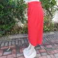 Smart red ankle length pencil style skirt in 100% wash and wear polyester. Slitted sides. Size 44/20