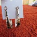 Pair of oval hooped earrings. Silver toned with animal print tops on gold and black. New item