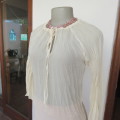 Pretty long permanent creased high-low cream top with long angel point sleeves size 32/8. As new.
