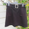 Little black ribbed polyester skirt. For girl 12 to 13 years old. Buckle on front. As new.