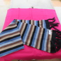 As new. Men`s knitted scarf in brown, cream, grey, blue and black stripes. Size 160cm x 23cm.