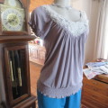 Silvergrey slip over top with tiny white polkadots.Small elasticated raglan sleeves. Size 32/8.