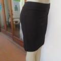 Black bodycon stretch polyester knee length skirt in size 32/8 by `MASSUMI`. New condition.