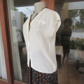 Soft cream embroidered top in size 36/12 by ACKERMANS. V neckline and button down. Good condition..