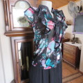 Glamorous button down top in black stretch polyester with lilac/turquoise flowers. Size 32/8 by RT.