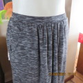 Maxi skirt in black with broken white horizontal lines. Some gathering and 2 side pockets. Size 32/8