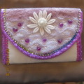 Beautiful white padded envelope style bag with purple trimmings. Size 18 x 12.5cm.Close on front.