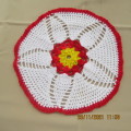 Crochet doiley in white with red flower and yellow inner. 33cm diameter. In wool. As new