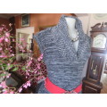 Stylish black/white mottled long acrylic knit sleeveless top.Foldover fireside collar.Size 36/12.