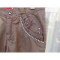 Shiny olive green skinny pants with back/front pockets. Faux diamond decoration. For 13/14 yr old.