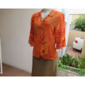 Bright orange/brick colour patterned button down top with collar by ZOEY size 36/12.Flare cuffs.
