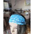 Skyblue folded polycotton hairband with white flowers and glitter.Elastic band at back.New condition