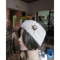 Charming wide hand knitted acrylic cream headband with bow at side. Glamour pin on bow. As new.