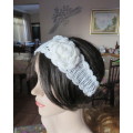 Delicate crochet acrylic stretch cream headband fasten with button at back and flower at side.